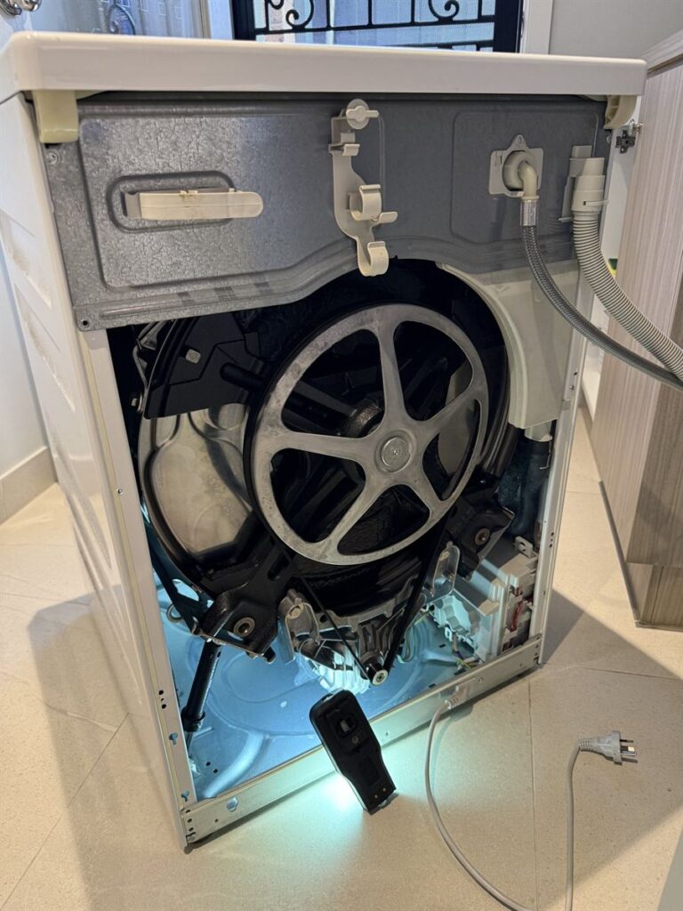 Miele washing machine with the rear panel removed during the damper replacement